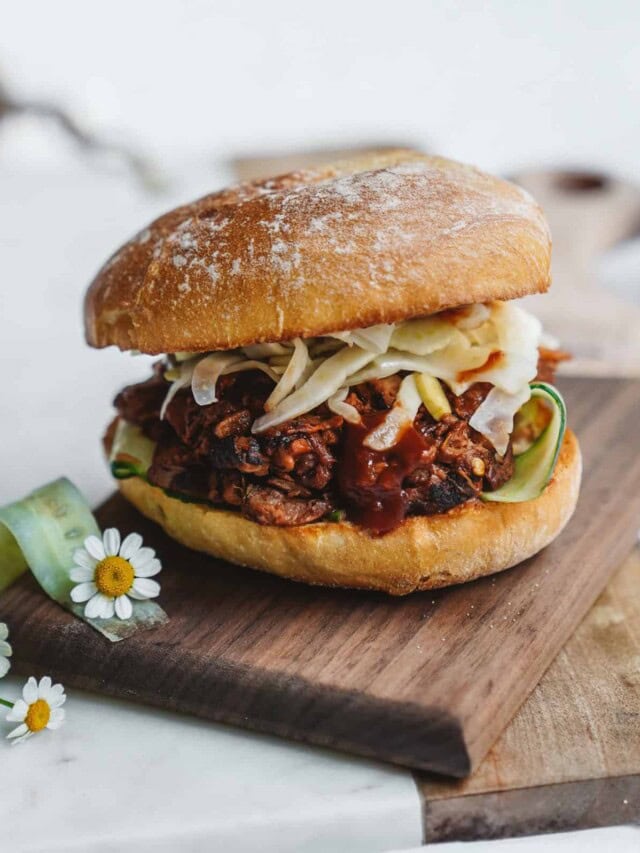 Jackfruit Burger stacked perfectly on a cutting board with fennel slaw.