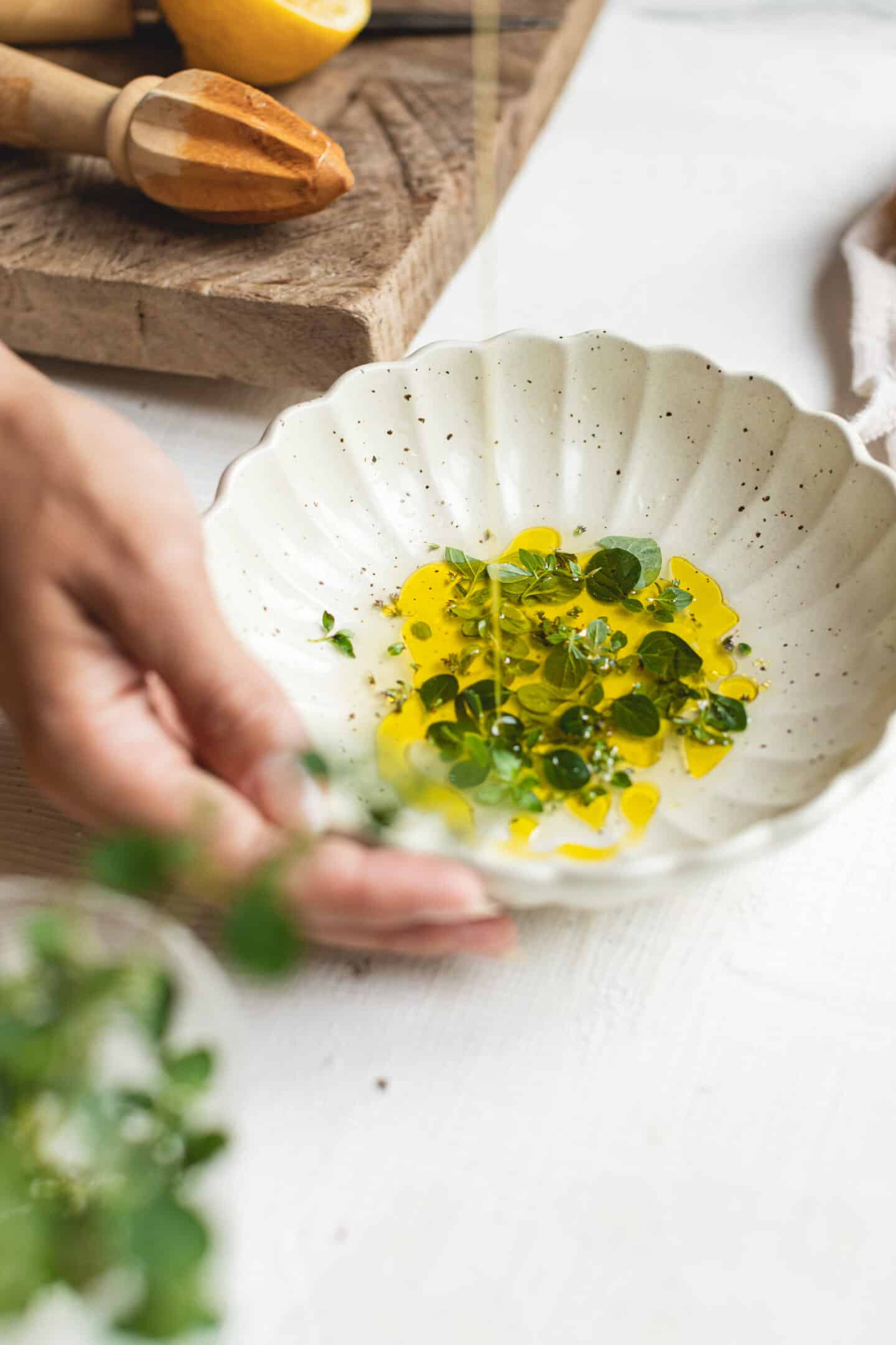 Hands holding a bowl with dressing ingredients