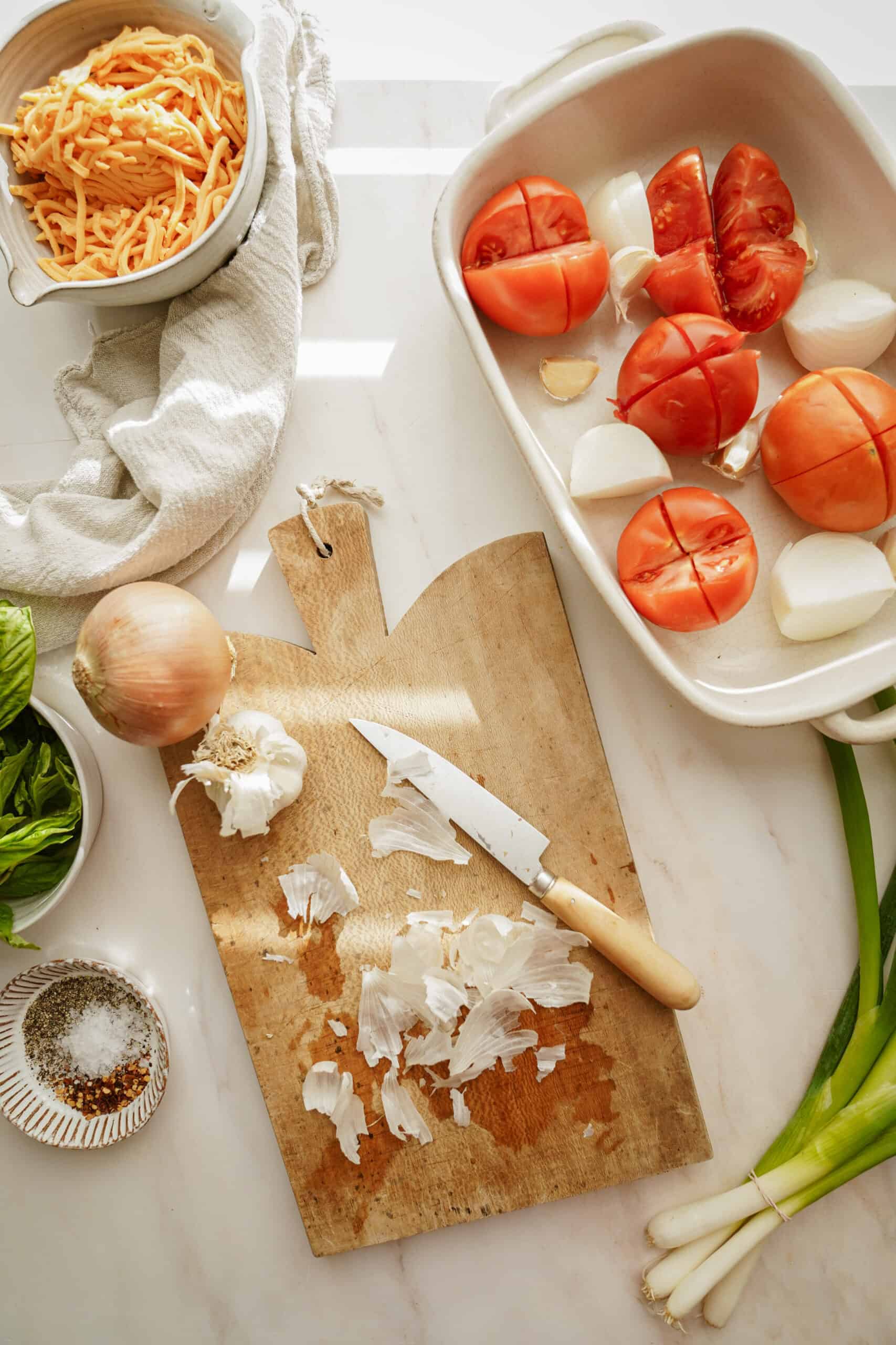 Prep for creamy tomato soup on a cutting board