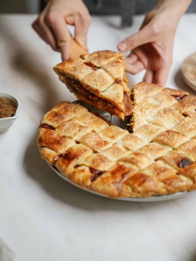 Homemade apple pie with a piece being lifted out of it