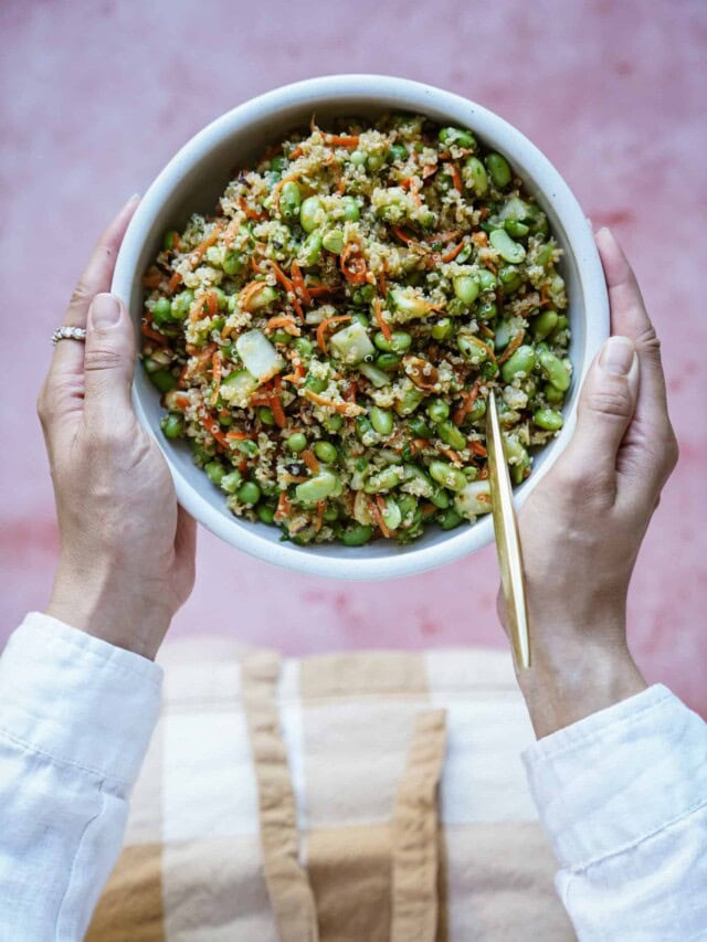 hands holding edamame salad