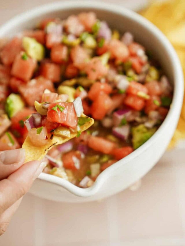 Close up of hand dipping chip into vegan ceviche