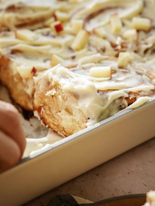 Apple Fritter Cinnamon Rolls being removed from a pan