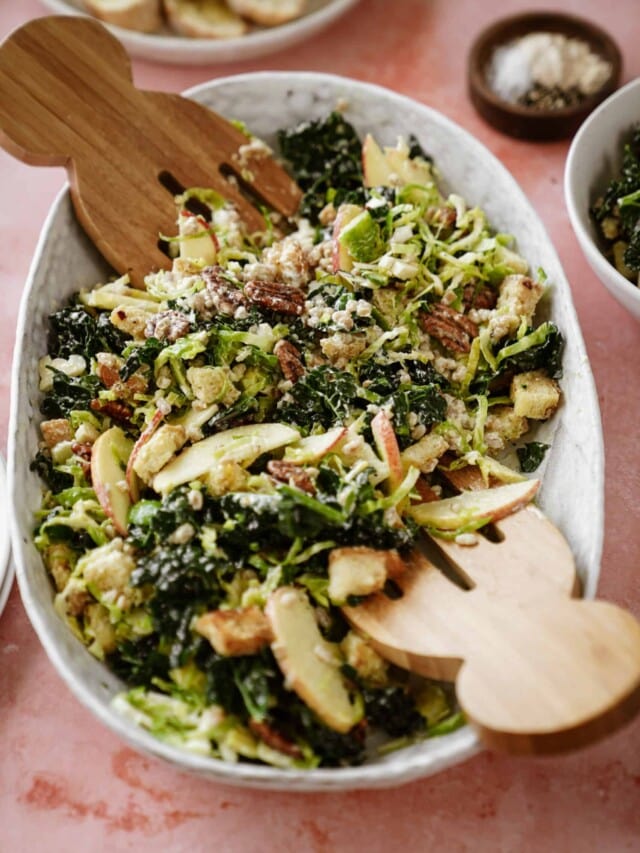 Winter chopped salad in a serving bowl with dressing recipe on top