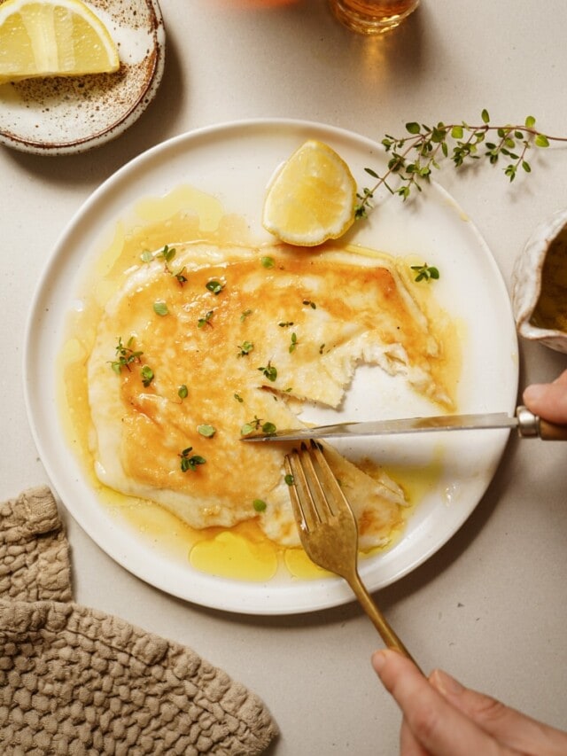 Saganaki on a serving dish with a fork and knife cutting it