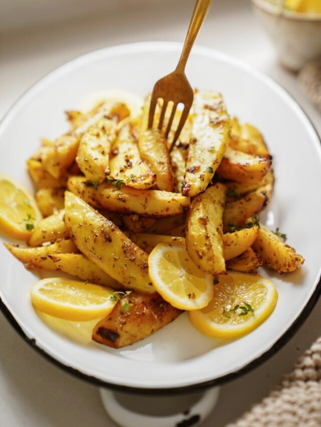 Greek Potatoes on a plate with a fork in them