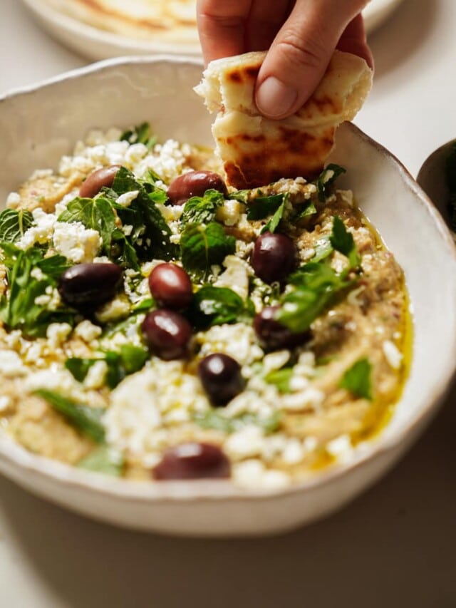 Whipped eggplant dip with a pita dipping into it