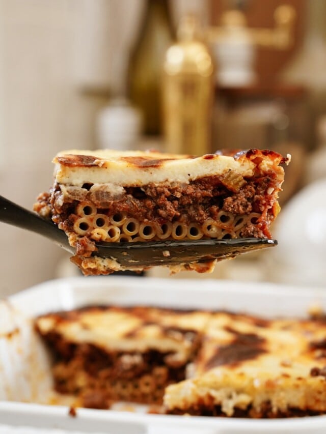 Sliced piece of pastitsio coming out of a casserole dish