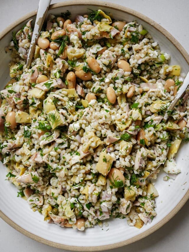 Mixed healthy chicken salad in a bowl with serving spoons