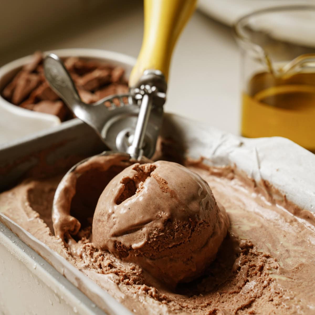 Chocolate ice cream being scooped out of container