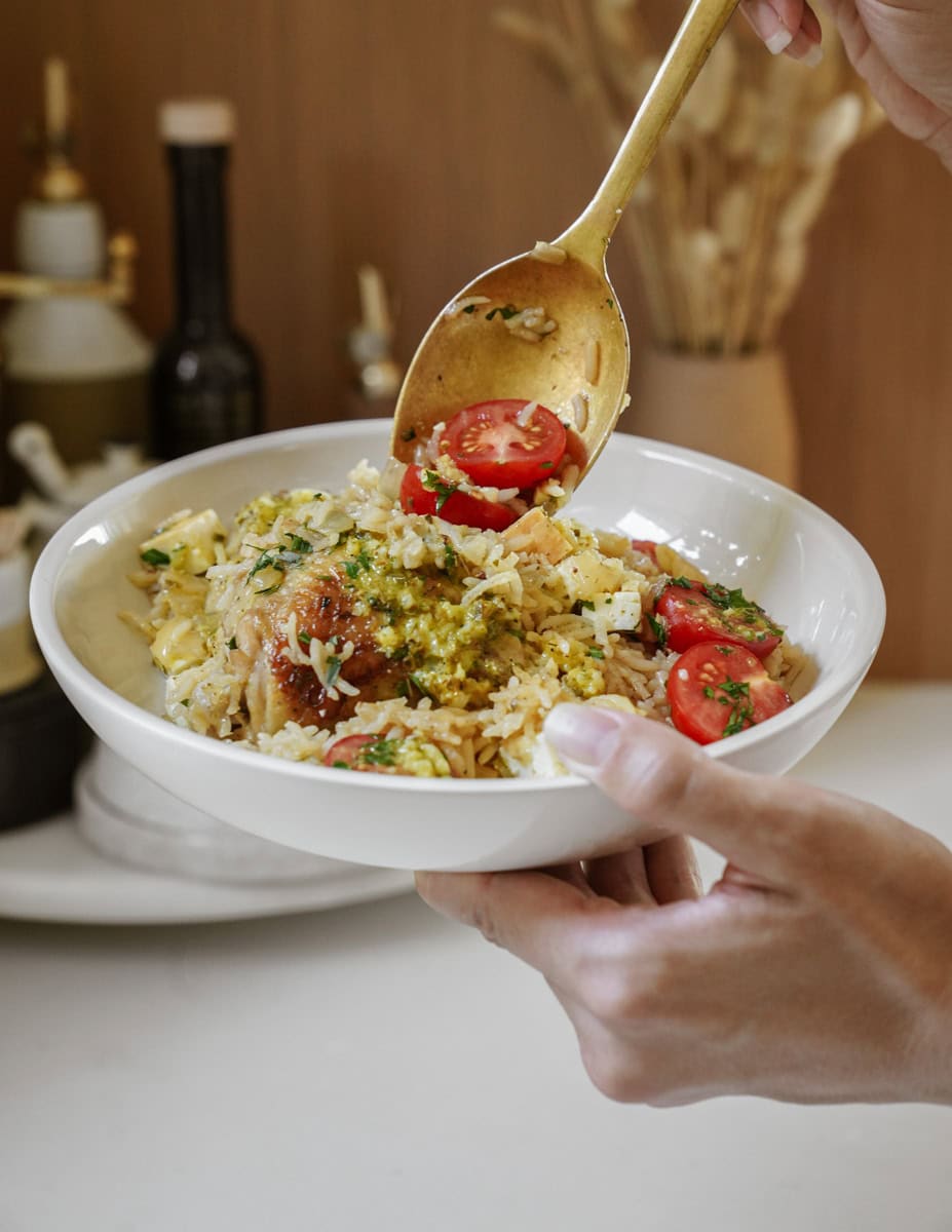 Spoon scooping chicken and rice into a bowl