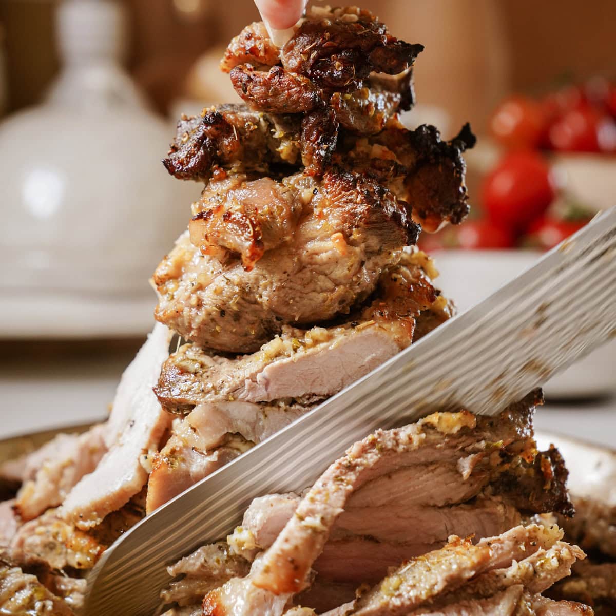 A golden-brown, crispy pork gyro on a vertical spit, with a long sharp knife shaving off half the pork gyro into thin, juicy slices.